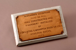 This bronze plate from the wheelhouse of the Alexander Grantham is engraved with the name "Hong Kong & Whampoa Dock Co Ltd" and its year of completion, "1953". It serves as the ship's production certificate. 